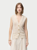 A woman wearing a beige sleeveless cashmere vest with a round neckline and button closures, paired with a white skirt. #color_off-white