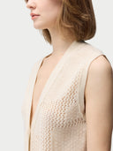 A woman wearing a beige sleeveless cashmere vest with a round neckline #color_off-white