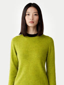 Women's Spinach Green Cashmere Crewneck Sweater worn by model, detail view on white background