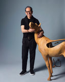 Naoki Takizawa standing beside a carved wooden horse in a photo studio