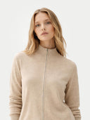 A light beige knit zip-up cashmere jacket with a mock neck, ribbed cuffs, and side pockets, displayed against a light gray background. #color_dusty-beige