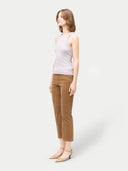 A woman wearing a ribbed cotton silk cashmere blend tank top in primrose pink color, paired with brown trousers. #color_wind-chime