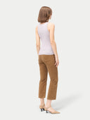 A woman wearing a ribbed cotton silk cashmere blend tank top in primrose pink color, paired with brown trousers. #color_wind-chime