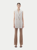 Front view of wind chime double-breasted sleeveless vest worn with brown ribbed flared pants