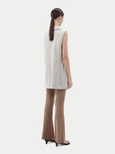 Back view of the wind chime sleeveless vest worn with brown ribbed flared pants