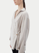 Woman wearing a light gray cashmere blouse with a plain background. #color_wind-chime
