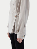 Woman wearing a light gray cashmere blouse with a plain background. #color_wind-chime