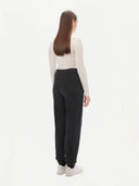 A pair of charcoal women's cashmere joggers with a ribbed hem and elastic waistband. #color_charcoal