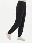 A pair of charcoal women's cashmere joggers with a ribbed hem and elastic waistband. #color_charcoal