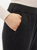 A pair of charcoal women's cashmere joggers with a ribbed hem and elastic waistband. #color_charcoal