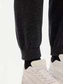 A pair of charcoal women's cashmere joggers with a ribbed hem and elastic waistband. #color_charcoal