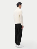 A man wearing a white turtleneck cashmere sweater with long sleeves. #color_off-white