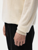 A man wearing a white turtleneck cashmere sweater with long sleeves. #color_off-white