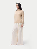 Cashmere Turtleneck Sweater Beige worn by model, side view, on white background
