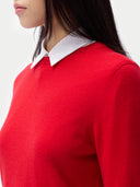 Red cashmere sweater with white collar worn by a person. #color_true-red