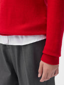 A woman wearing a red cashmere crew neck sweater with a white collar and gray pants. #color_true-red