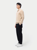 Men‚Äôs beige cashmere polo sweater worn by model, side view on white background #color_beige