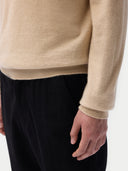 Men‚Äôs beige cashmere polo sweater worn by model, detail view on white background #color_beige
