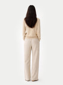 Woman wearing a beige cashmere sweater against a white background. #color_beige