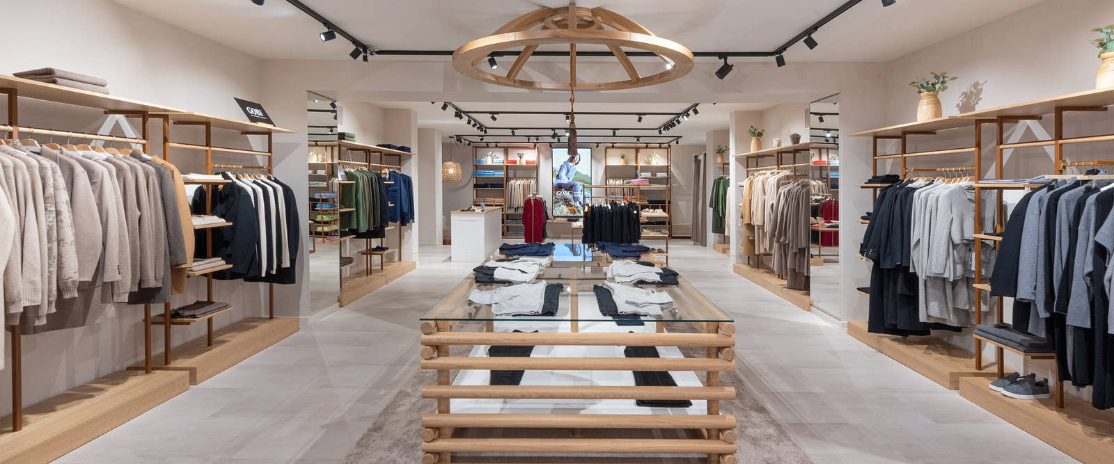 Interior of a Gobi Cashmere boutique with cashmere knitwear displayed on warm wooden shelves and rails