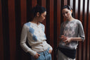 Two models in GOBI argyle cashmere knitwear against wooden panelling