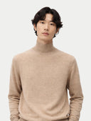 Man wearing a beige turtleneck cashmere sweater against a white background. #color_soft-beige