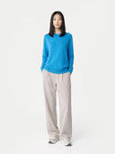 Person wearing a blue sweater and beige pants on a white background.  #color_cendre-blue