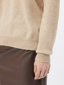 A light beige knit cashmere turtleneck sweater with long sleeves and ribbed cuffs and hem, displayed against a clean white background. #color_soft-beige