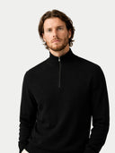 Man wearing a black quarter-zip cashmere sweatshirt against a white background