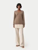 Woman wearing a brown cashmere sweater against a white background #color_taupe
