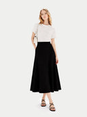 Woman wearing a white top and black skirt on a white background