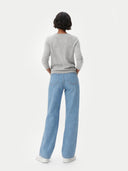 Person wearing a gray cashmere sweater and light blue jeans on a white background. #color_steel-silver