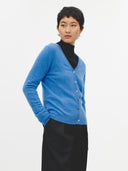 Blue cashmere cardigan on a light gray background. #color_blue