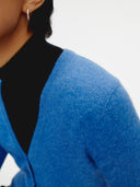 Blue cashmere cardigan on a light gray background. #color_blue