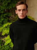 Men's Black Turtleneck Cashmere Sweater worn by model, detail view on white background