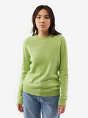 Person wearing a green sweater and blue jeans on a white background. #color_jade-green